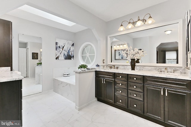 11166 Deuaughn Ct, Fairfax Station, VA 22039 - full bathroom featuring double vanity, marble finish flooring, a garden tub, and a skylight
