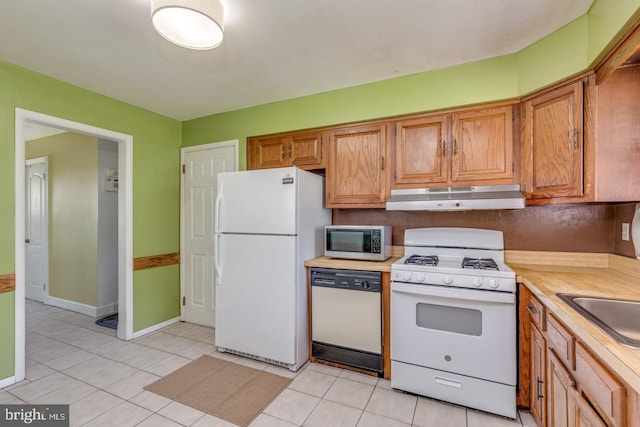601 King George Rd, Cherry Hill, NJ 08034 - kitchen with white appliances, under cabinet range hood, light countertops, light tile patterned floors, and brown cabinets