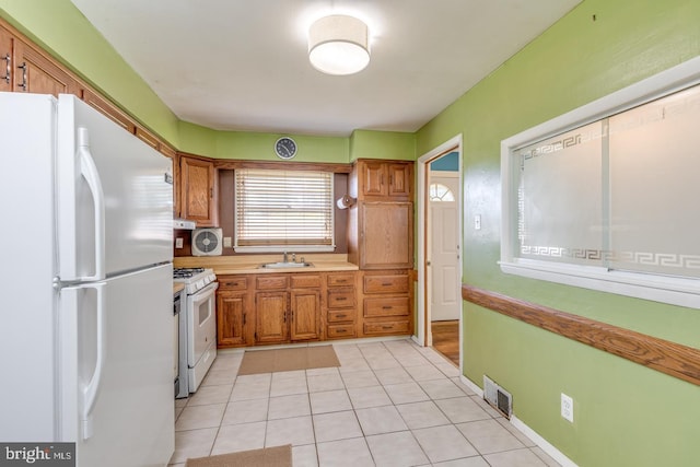 601 King George Rd, Cherry Hill, NJ 08034 - kitchen featuring white appliances, light tile patterned floors, brown cabinets, and light countertops