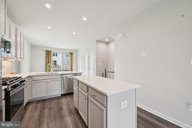 3745 Cedar Mountain Way, Hanover, MD 21076 - kitchen with stainless steel appliances, dark wood-style flooring, a peninsula, light countertops, and a center island