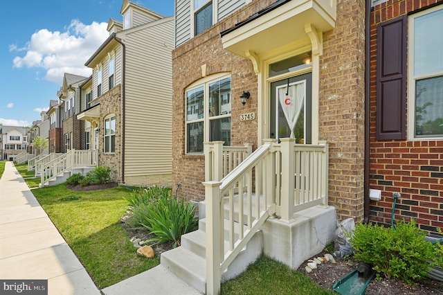 3745 Cedar Mountain Way, Hanover, MD 21076 - view of exterior entry featuring brick siding, a residential view, and a lawn