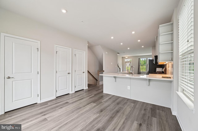 3745 Cedar Mountain Way, Hanover, MD 21076 - kitchen with a peninsula, light wood-type flooring, open shelves, a kitchen bar, and light countertops
