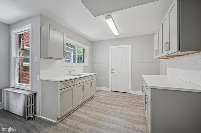 510 E Queen Ln, Philadelphia, PA 19144 - kitchen featuring gray cabinets, radiator, light countertops, and light wood-style flooring