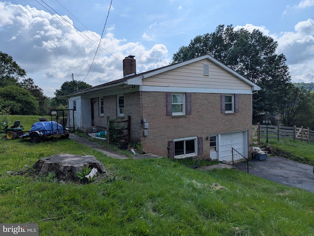 44 Chestnut St, Adamstown, PA 19501 - rear view of house featuring asphalt driveway, brick siding, a chimney, and a garage