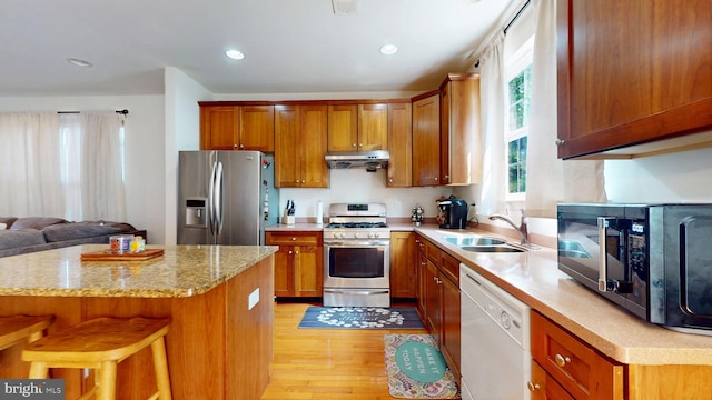 47 Buck Rd, Mays Landing, NJ 08330 - kitchen featuring stainless steel appliances, light wood-style floors, under cabinet range hood, a kitchen bar, and brown cabinetry