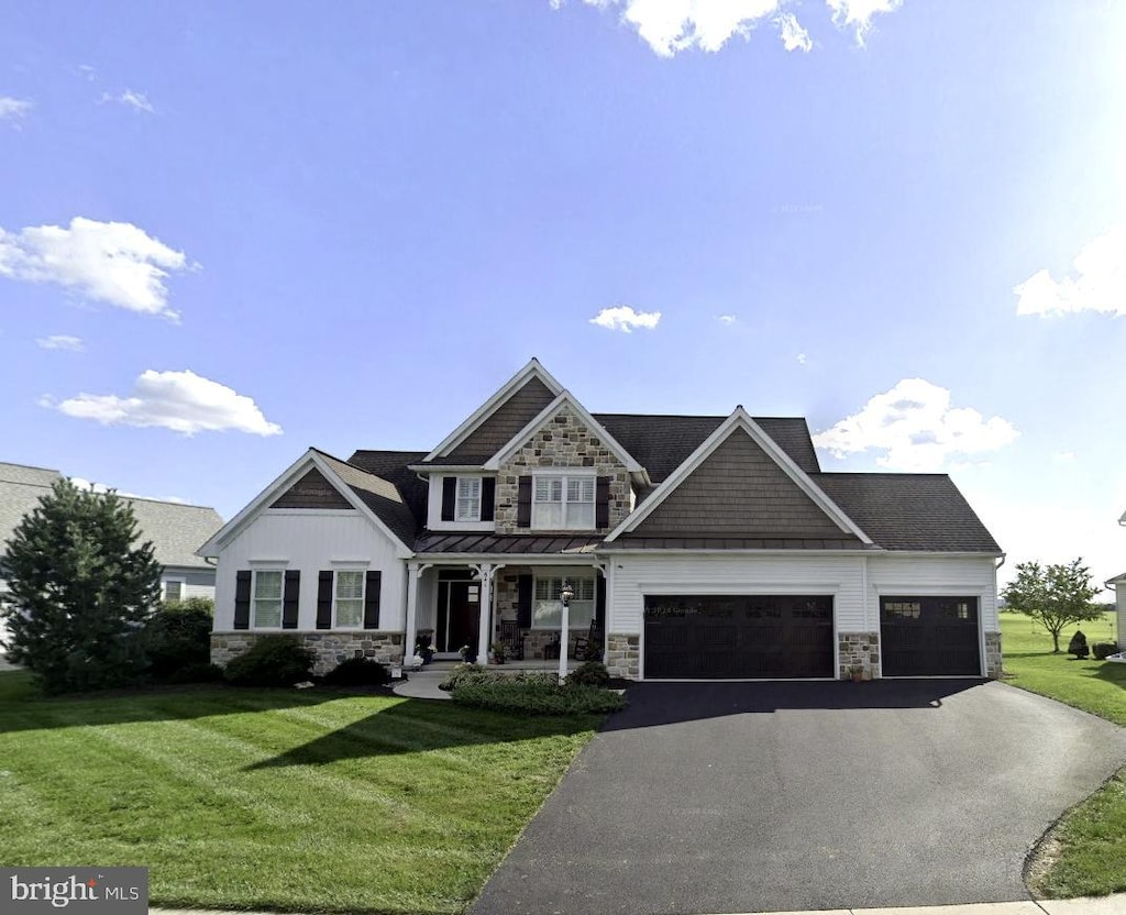 641 Skyler Dr, Mount Joy, PA 17552 - view of front of property with stone siding, a porch, an attached garage, asphalt driveway, and a front yard