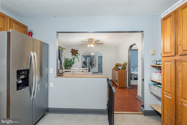 5200 Daybreak Ct, Baltimore, MD 21206 - kitchen featuring stainless steel fridge with ice dispenser, arched walkways, a ceiling fan, and brown cabinetry