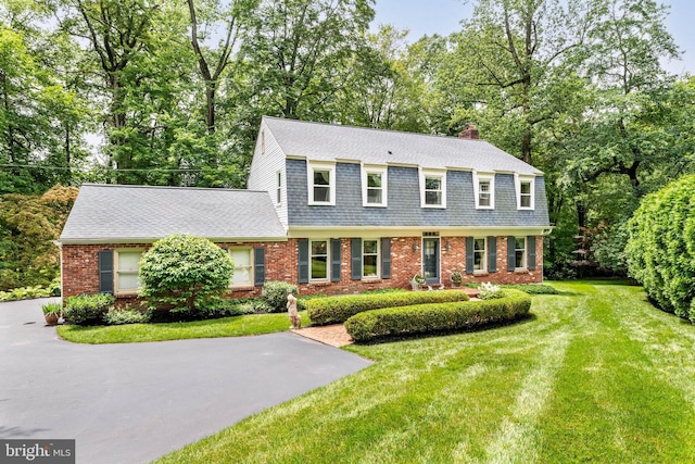 544 N Wayne Ave, Wayne, PA 19087 - view of front of house featuring brick siding, a chimney, a shingled roof, a gambrel roof, and a front yard