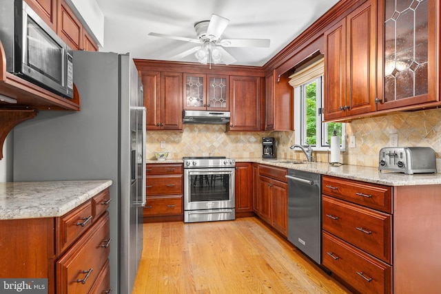 544 N Wayne Ave, Wayne, PA 19087 - kitchen with stainless steel appliances, under cabinet range hood, light wood finished floors, ceiling fan, and tasteful backsplash