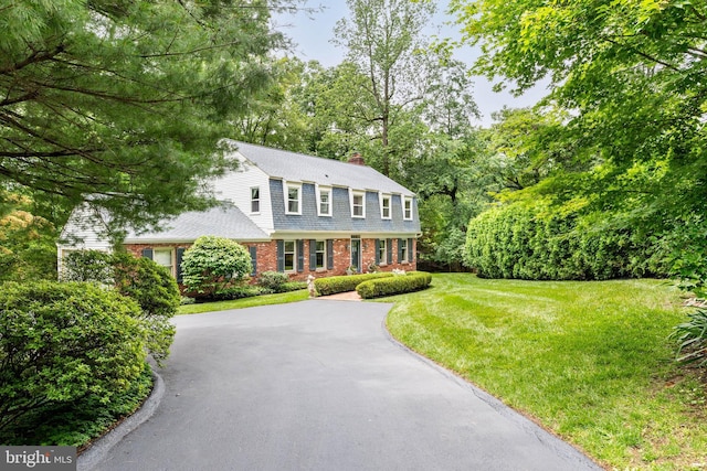 544 N Wayne Ave, Wayne, PA 19087 - colonial home featuring brick siding, a chimney, driveway, a gambrel roof, and a front lawn
