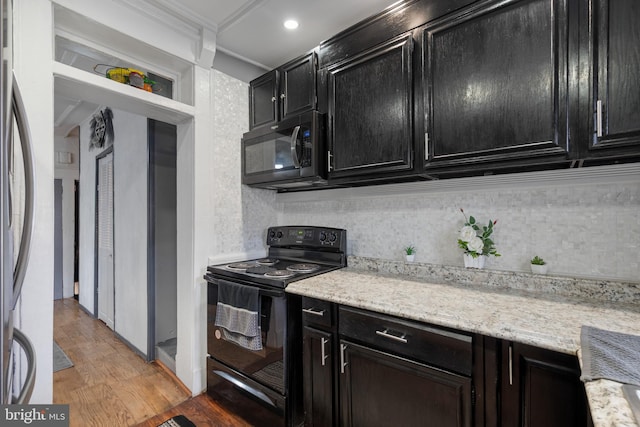 16 N Morley St, Baltimore, MD 21229 - kitchen featuring black appliances, dark cabinets, light wood finished floors, crown molding, and backsplash