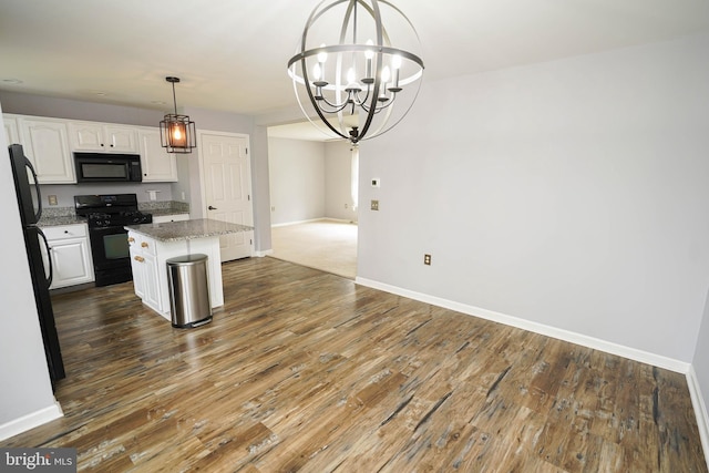 612 S Division St, Fruitland, MD 21826 - kitchen with black appliances, a kitchen island, white cabinetry, a chandelier, and wood finished floors