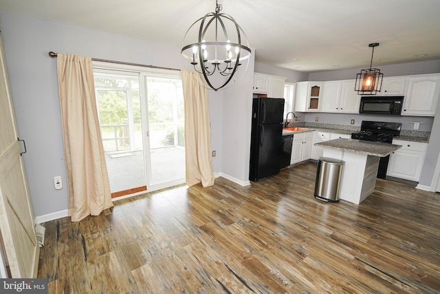 612 S Division St, Fruitland, MD 21826 - kitchen with black appliances, a chandelier, white cabinets, dark wood finished floors, and pendant lighting