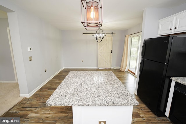 612 S Division St, Fruitland, MD 21826 - kitchen with black appliances, white cabinets, light stone countertops, a kitchen island, and dark wood finished floors