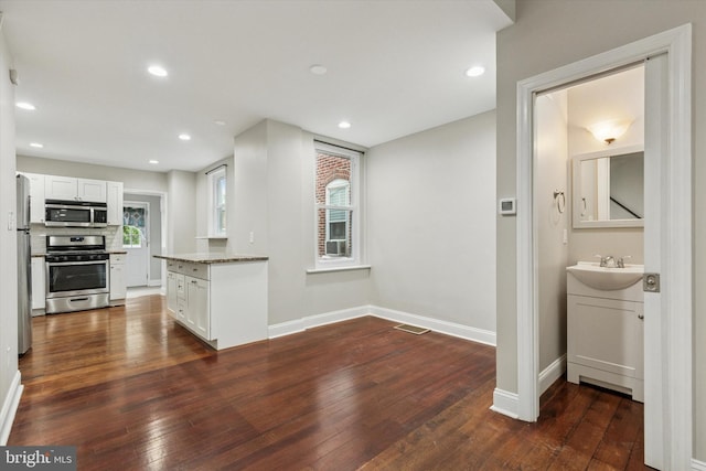 252 N 3rd St, North Wales, PA 19454 - kitchen featuring stainless steel appliances, dark wood-type flooring, white cabinetry, light stone counters, and recessed lighting