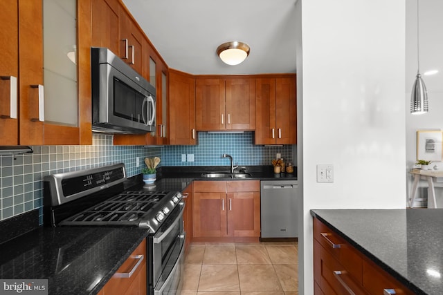 3515 Washington Blvd Unit 316, Arlington, VA 22201 - kitchen featuring appliances with stainless steel finishes, tasteful backsplash, dark stone counters, light tile patterned floors, and brown cabinetry