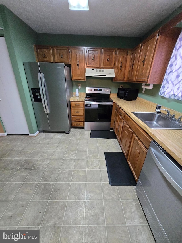 14 Riverside Run Dr, Indian Head, MD 20640 - kitchen with stainless steel appliances, under cabinet range hood, light countertops, light tile patterned floors, and brown cabinetry