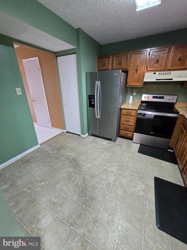 14 Riverside Run Dr, Indian Head, MD 20640 - kitchen featuring appliances with stainless steel finishes, under cabinet range hood, light countertops, light tile patterned floors, and a textured ceiling