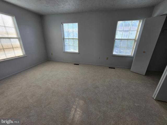 14 Riverside Run Dr, Indian Head, MD 20640 - unfurnished bedroom with multiple windows, carpet flooring, and a textured ceiling