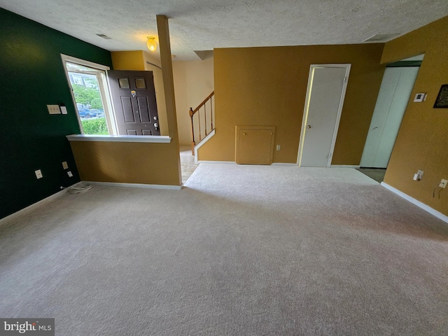 14 Riverside Run Dr, Indian Head, MD 20640 - unfurnished living room featuring a textured ceiling, stairs, and carpet floors