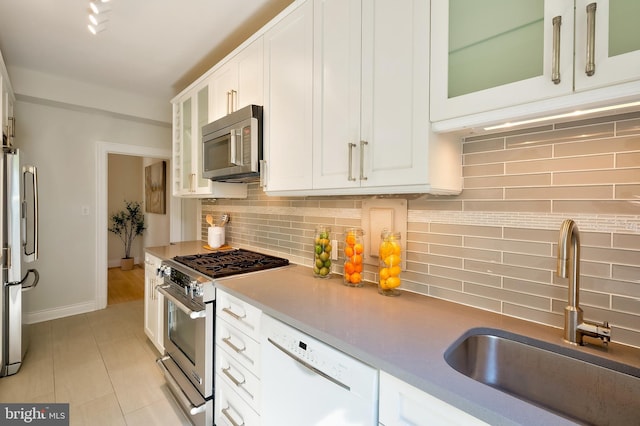 3100 Connecticut Ave NW Unit 434, Washington, DC 20008 - kitchen with appliances with stainless steel finishes, white cabinetry, tasteful backsplash, and glass insert cabinets