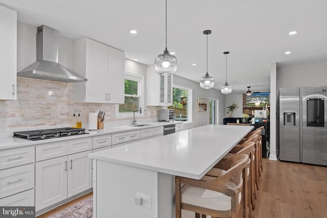 14731 Conway Dr, Manassas, VA 20112 - kitchen featuring stainless steel appliances, wall chimney exhaust hood, a center island, recessed lighting, and backsplash