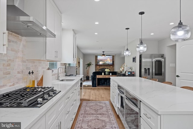 14731 Conway Dr, Manassas, VA 20112 - kitchen with stainless steel appliances, wall chimney exhaust hood, a center island, light wood-type flooring, and recessed lighting