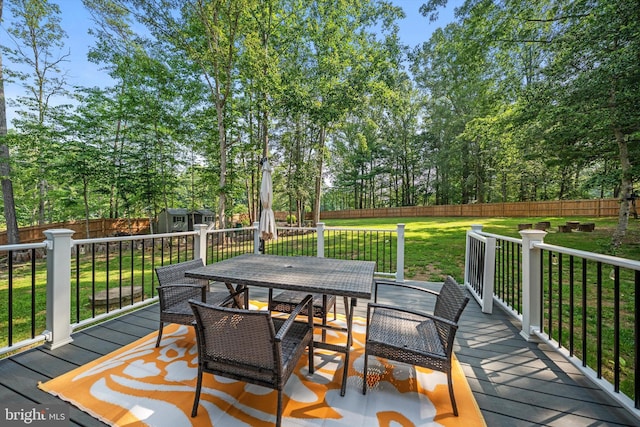 14731 Conway Dr, Manassas, VA 20112 - wooden terrace with outdoor dining area, a storage shed, a fenced backyard, and view of wooded area