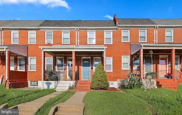 336 Imla St, Baltimore, MD 21224 - multi unit property with brick siding, a front yard, a porch, and cooling unit