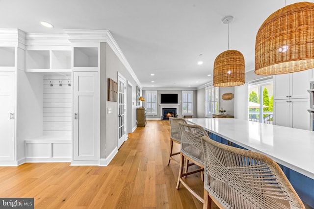806 Dunfer Hill Rd, Severna Park, MD 21146 - kitchen featuring light wood-type flooring, a kitchen bar, pendant lighting, a warm lit fireplace, and recessed lighting