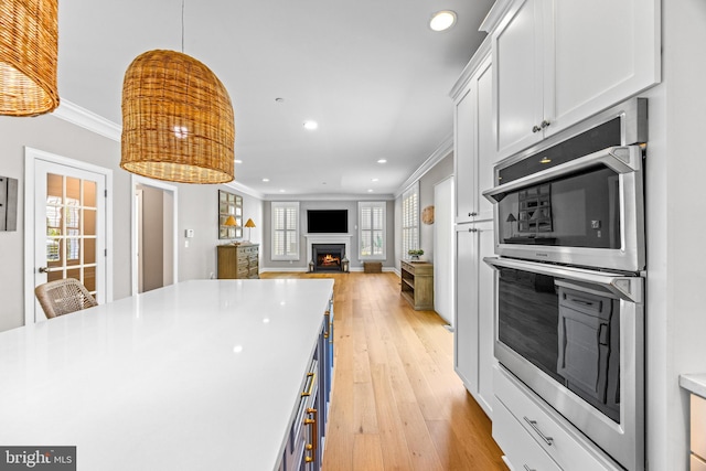 806 Dunfer Hill Rd, Severna Park, MD 21146 - kitchen with stainless steel double oven, ornamental molding, light wood-style floors, a lit fireplace, and recessed lighting
