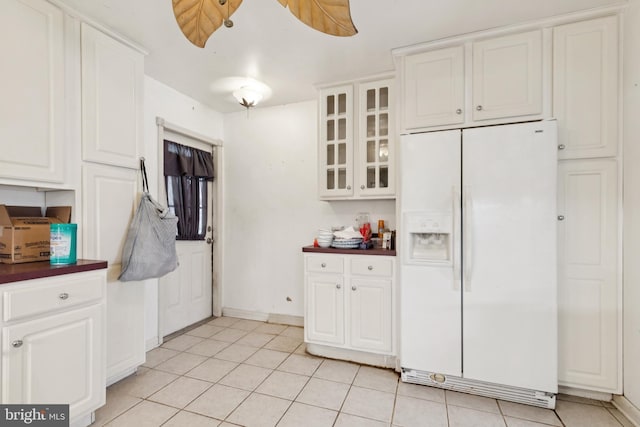 7022 High Bridge Rd, Bowie, MD 20720 - kitchen with white fridge with ice dispenser, dark countertops, glass insert cabinets, white cabinets, and light tile patterned floors