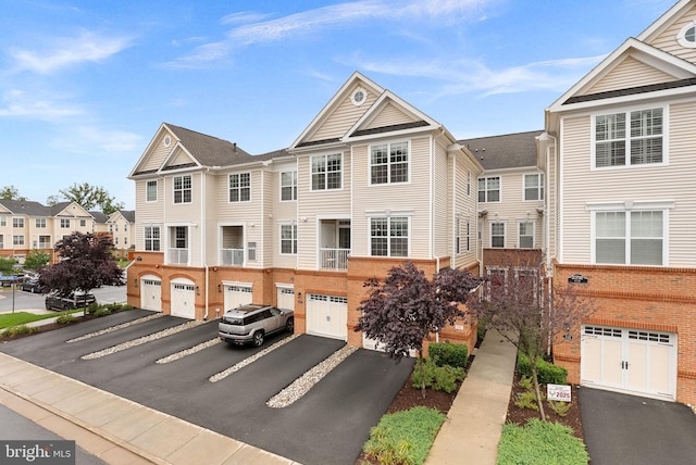 23230 Milltown Knoll Sq Unit 106, Ashburn, VA 20148 - view of front of home featuring driveway, a garage, a residential view, and brick siding