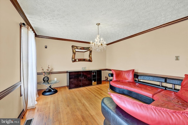 2700 Moores Valley Dr, Baltimore, MD 21209 - living room featuring wood finished floors, a chandelier, a textured ceiling, and ornamental molding