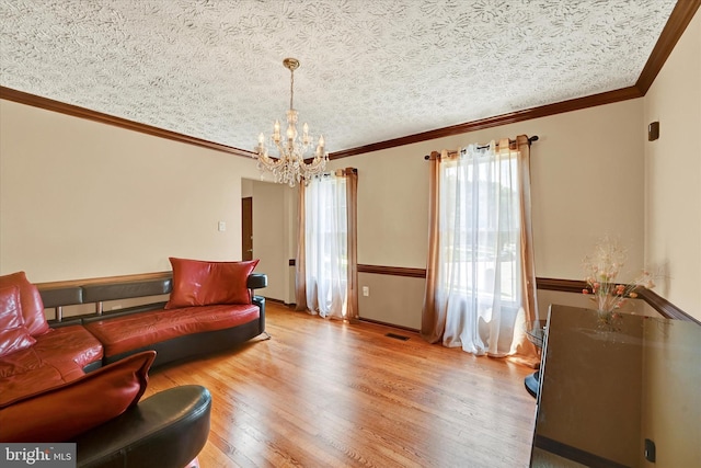 2700 Moores Valley Dr, Baltimore, MD 21209 - living room featuring a chandelier, light wood finished floors, crown molding, and a textured ceiling