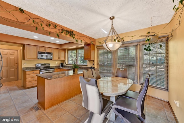 2700 Moores Valley Dr, Baltimore, MD 21209 - kitchen with stainless steel appliances, a textured ceiling, a breakfast bar area, decorative light fixtures, and recessed lighting