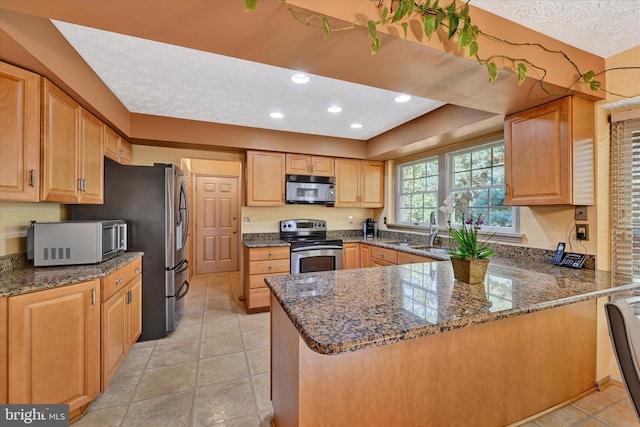 2700 Moores Valley Dr, Baltimore, MD 21209 - kitchen featuring stainless steel appliances, a peninsula, dark stone counters, a textured ceiling, and recessed lighting
