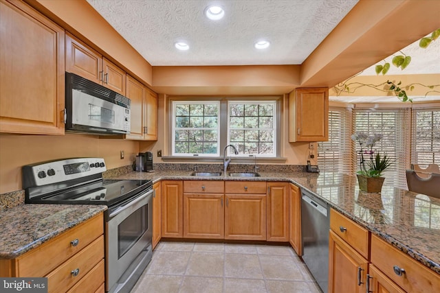 2700 Moores Valley Dr, Baltimore, MD 21209 - kitchen featuring appliances with stainless steel finishes, a textured ceiling, dark stone counters, brown cabinetry, and light tile patterned floors