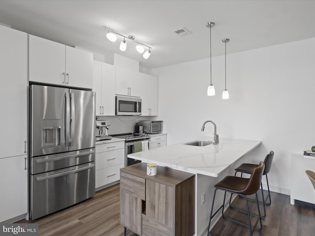 10755 Fairgrounds Dr Unit 223, Fairfax, VA 22030 - kitchen with stainless steel appliances, a breakfast bar, a peninsula, dark wood-style floors, and white cabinetry