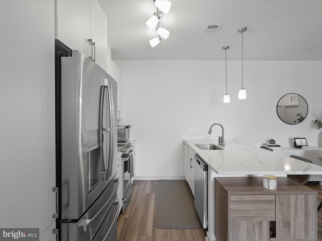10755 Fairgrounds Dr Unit 223, Fairfax, VA 22030 - kitchen featuring stainless steel appliances, a peninsula, light stone counters, dark wood finished floors, and modern cabinets