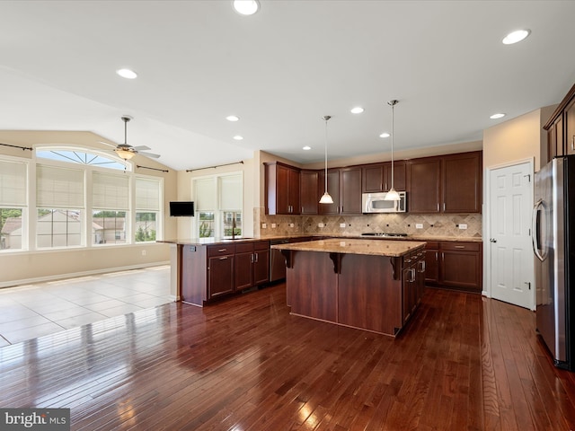 114 Renee Ln, Winchester, VA 22602 - kitchen featuring appliances with stainless steel finishes, dark wood-style floors, a kitchen island, a breakfast bar area, and a ceiling fan
