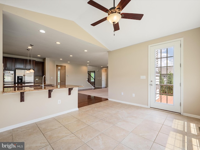 114 Renee Ln, Winchester, VA 22602 - kitchen with stainless steel appliances, a kitchen bar, vaulted ceiling, light tile patterned floors, and light stone counters