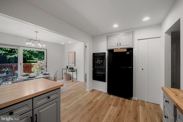 6128 Buckingham Manor Dr, Baltimore, MD 21210 - kitchen with wood counters, black appliances, light wood-style flooring, recessed lighting, and a chandelier