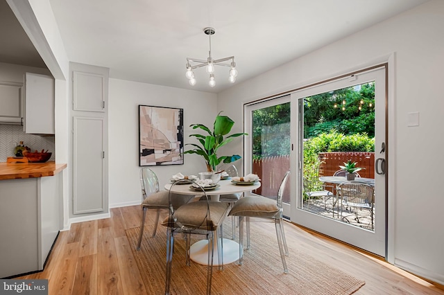 6128 Buckingham Manor Dr, Baltimore, MD 21210 - dining area with light wood-style flooring and a chandelier
