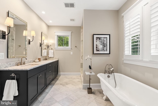 2407 N Nelson St, Arlington, VA 22207 - bathroom featuring marble look tiles, double vanity, a soaking tub, and recessed lighting