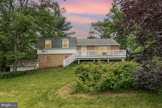 30 Bunker Ln, Etters, PA 17319 - back of house at dusk featuring brick siding, a lawn, a deck, and roof with shingles