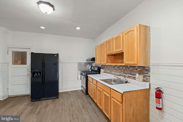 1245 Chase St, Camden, NJ 08104 - kitchen with black fridge, range with gas stovetop, ventilation hood, light countertops, and light wood-style flooring