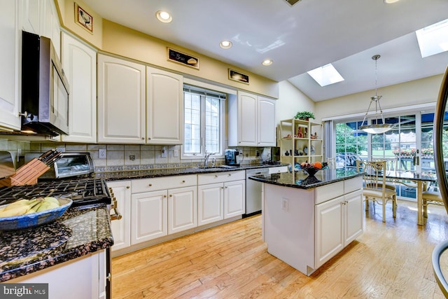 57 Harwood Rd, Monroe Township, NJ 08831 - kitchen featuring a skylight, stainless steel appliances, white cabinetry, backsplash, and light wood-type flooring