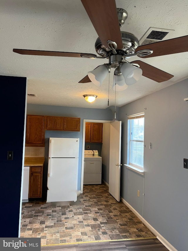 2177 Fawn Ct, Waldorf, MD 20602 - kitchen featuring white appliances, washer / clothes dryer, a ceiling fan, and brown cabinetry