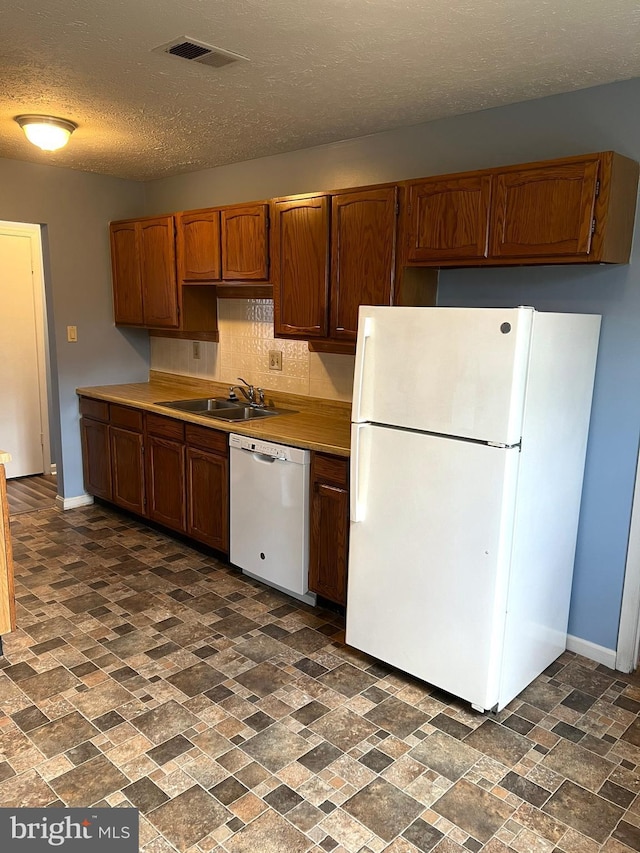 2177 Fawn Ct, Waldorf, MD 20602 - kitchen with white appliances, brick patterned flooring, decorative backsplash, light countertops, and a textured ceiling
